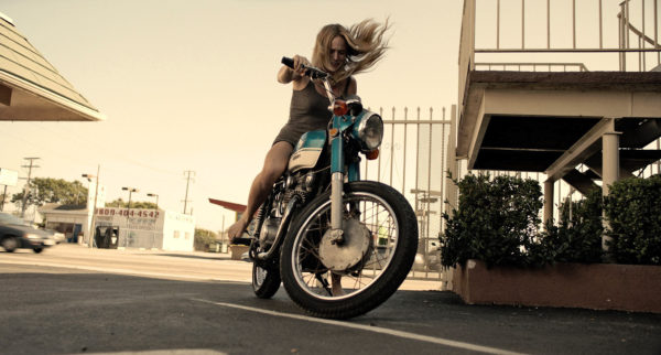 Caity Lotz trying to kick start her motorcycle