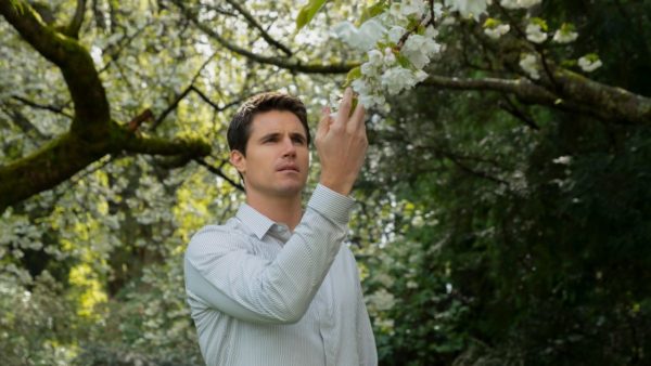 Nathan (Robbie Amell) touches a flower on a tree