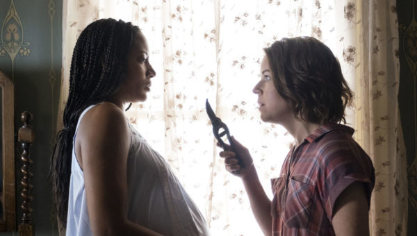A white woman threatens a pregnant black woman with shears