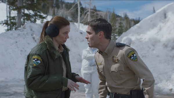 A female police officer tries to talk down a male co-worker who stares at her incredulously