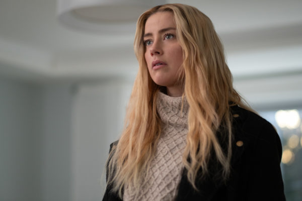 Nadine Cross (Amber Heard), a blonde woman in a knit white sweater and black jacket