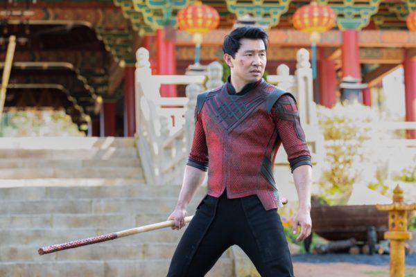 Shang-Chi (Simu Liu) grips a baton in front of a temple