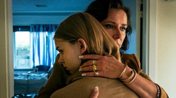 An older woman hugs a teen girl