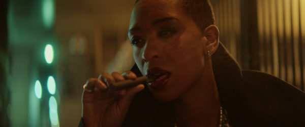 A Black woman smokes an e-cigarette