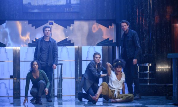 A group of people standing in front of a stairwell and set of doors