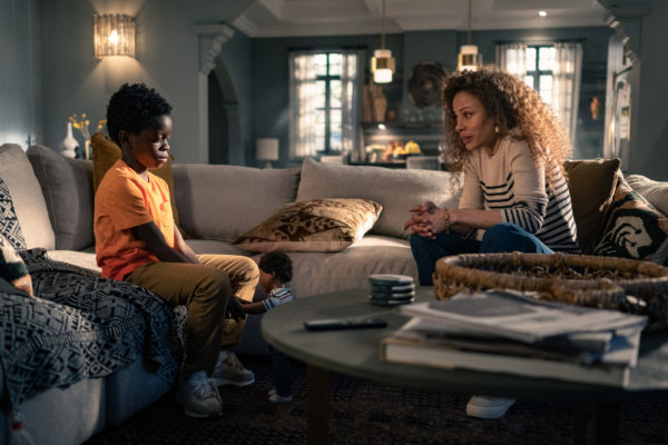 A pre-teen boy (L) stares at his mother (R) on the couch