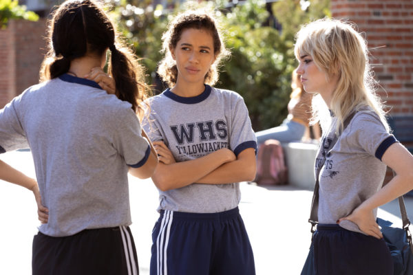 3 teen girls in soccer uniforms chat outside