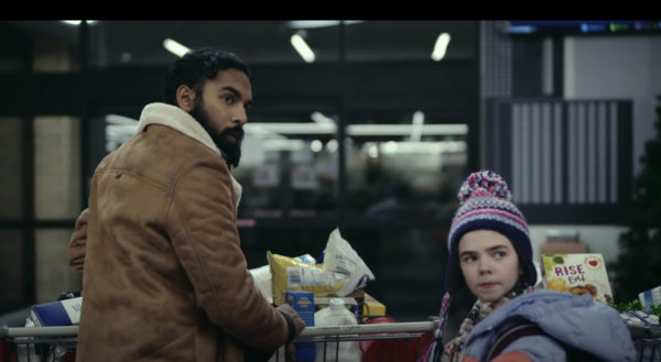 A man and a young girl push a grocery cart