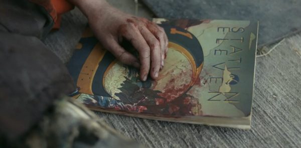 A close up of a wounded hand resting on a comic