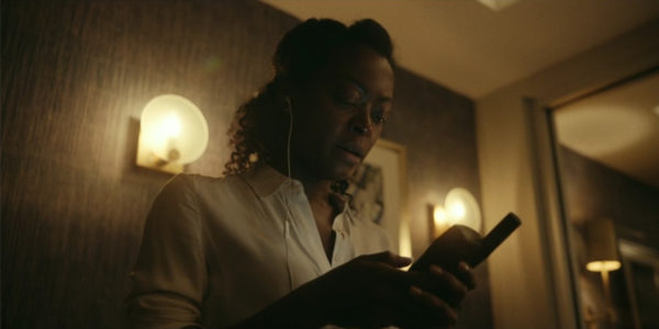 A woman in a white shirt speaking on a satellite phone