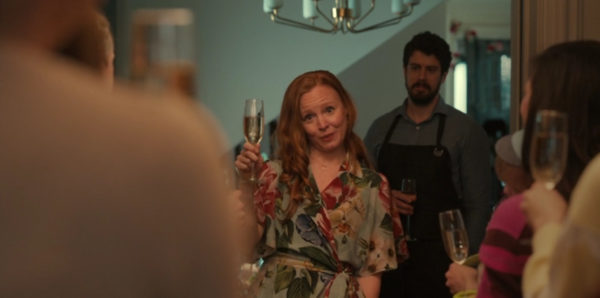 A red headed woman toasts with champagne