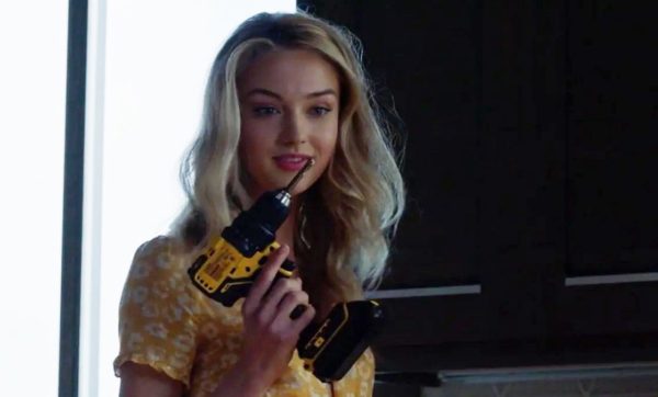 A blonde woman holding a power drill