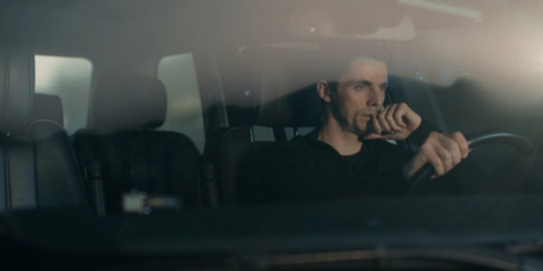 A dark haired man driving