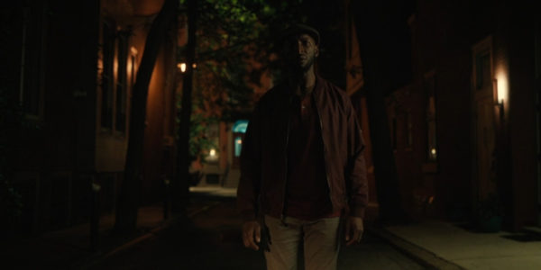 A black man in standing in the street