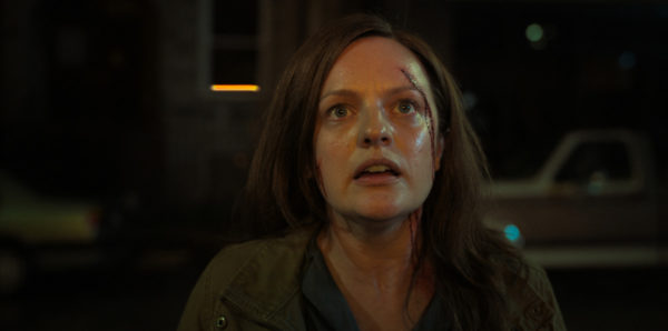 A bloodied woman stares at something just above the camera