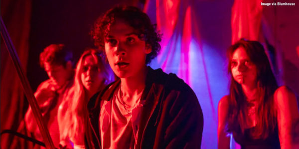A group of bloody teens in a red lit warehouse