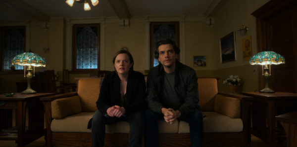 A man and a woman sit on a couch