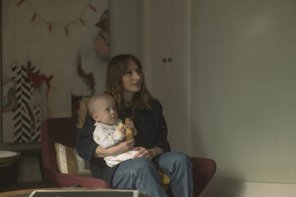 A seated white woman holds a baby