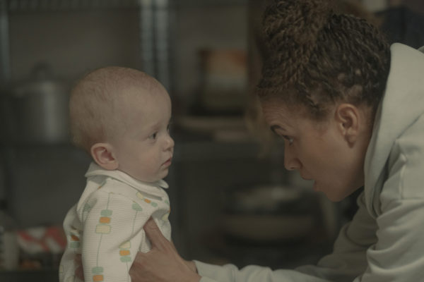 A black woman (R) stares at a baby (L)