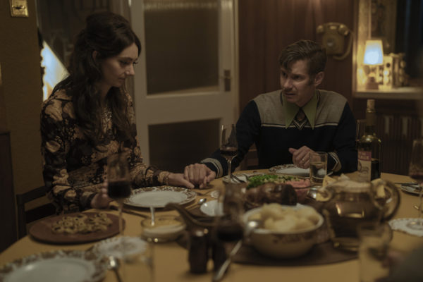 A woman (L) eating dinner with a man (R) in the 70s