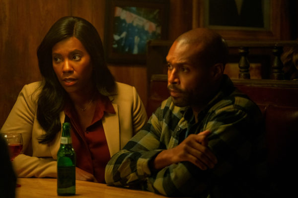 A black man and woman sitting at a table looking concerned