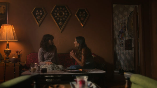 A girl (R) speaks with her mom (L) on the couch