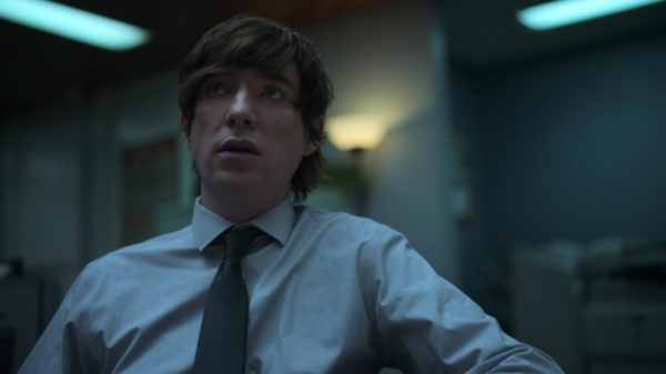 A man (Domhnall Gleeson) in a dress shirt and tie in blue lighting