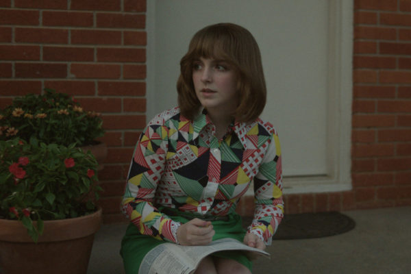 Mckenna Grace as 13 year old Jan Broberg, sitting on the front doorstep