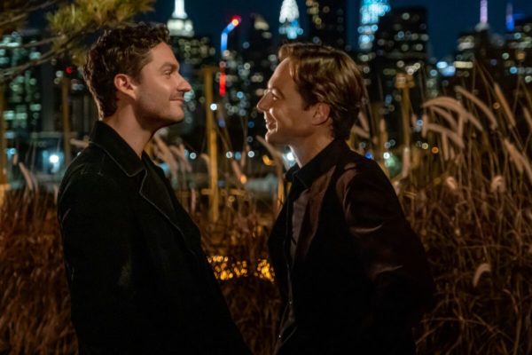 Two men gaze at each on a rooftop at night