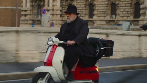 Russell Crowe as Father Amorth, riding a Lambretta scooter