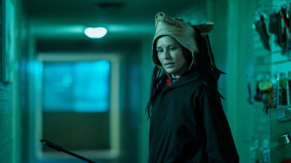 Amanda (Shawnee Smith) wearing a red robe and a pig mask perched on her head