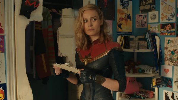 Brie Larson as Captain Marvel, looking at a paper in a teenager's room