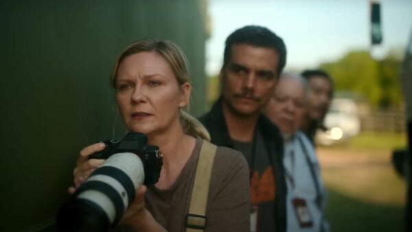 Lee Smith (Kirsten Dunst - foreground) prepares to shoot her telescope lens camera as Joel (Wagner Moura - background) watches