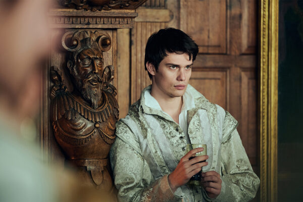 George (Nicolas Galitzine) sitting, wearing a white shirt