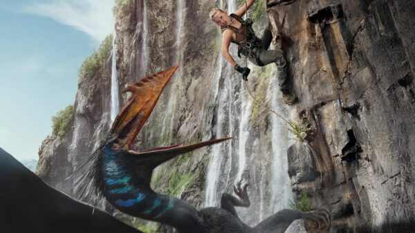 A blonde woman rapelling down a cliffside (r) as an angry flying dinosaur opens its beak at her