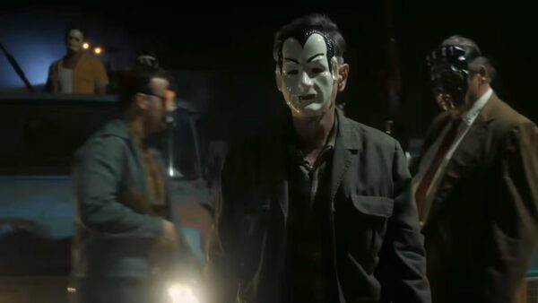 Three men in masks. One holds a flashlight