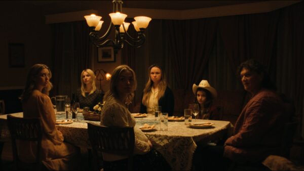 A long shot of 5 women sitting around a dimly lit table