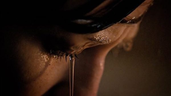 Still of water pouring over Carrie Coon's face