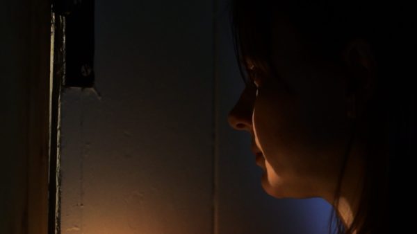 Tracey Ann Wood as Joyce, peering through a keyhole