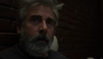 A bearded man (Steve Carell) in dark close-up