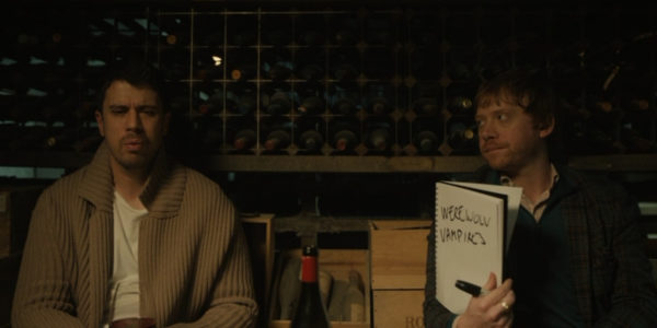 Sean (Toby Kebbell - L) and Julian (Rupert Grint - R), holding a whiteboard that reads Vampires and Werewolves