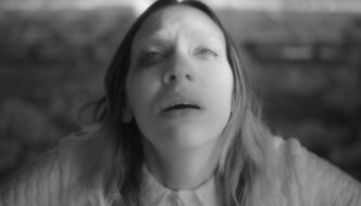 A high angle shot in black and white of a woman with her face turned up to the camera in religious ecstasy